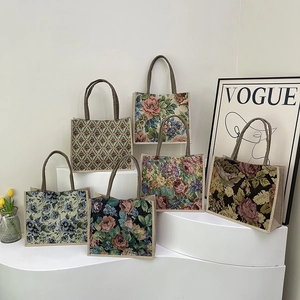 Linen floral tote bags in vintage jacquard patterns with woven handles on white display