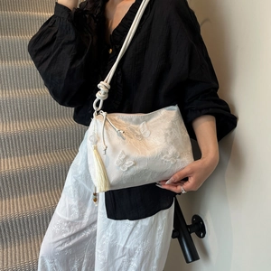 Sac bandoulière blanc en soie avec broderies papillons porté par un mannequin