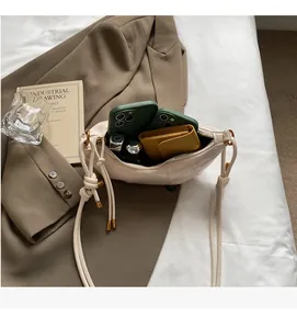 Detailed interior of vintage beige dumpling bag showing storage space for phone and wallet