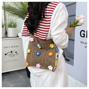 Detail of crochet tote bag with 3D colorful floral patterns and brown woven texture