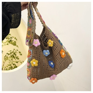Detail of handmade crochet tote bag with colorful hollow floral knit pattern and wide strap