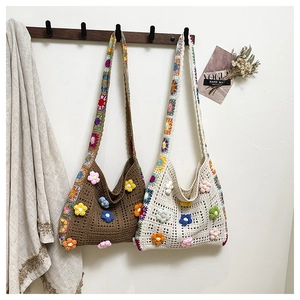 Bohemian crochet tote bags with 3D floral accents hanging in a rustic setting
