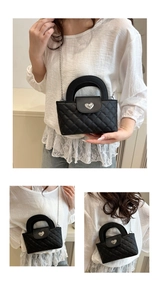 Details einer schwarzen Stepptasche mit herzförmigem Metallverschluss und silberner Kette