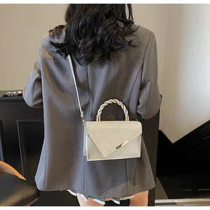 Silver glitter shoulder bag with braided handle and unique diagonal cut flap detail
