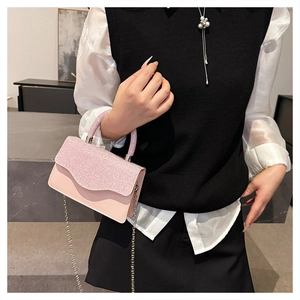 Detail of pink glitter square bag with wavy flap design and rhinestone handle strap