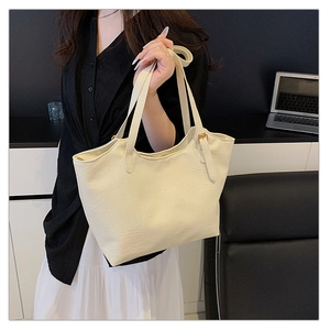 Detailed close-up of cream white soft leather tote with elegant gold buckle strap