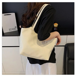 Lifestyle shot showing a large ivory tote bag on a model's shoulder for commuting