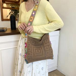 Handmade crochet shoulder bag with brown woven texture and colorful sunflower patterns