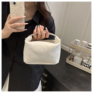 Detailed view of the white snakeskin embossed texture on the leather handbag