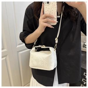 Close-up of white snake pattern texture on a trendy retro pillow crossbody bag