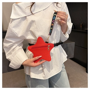 Detailed shot of a red star-shaped crossbody bag with a LOVE printed strap worn on waist