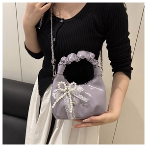 Fliederfarbene Lackleder-Tasche mit großer weißer Spitzenschleife und Perlen-Herz-Anhänger