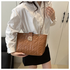 Brown quilted tote bag with gold chain strap and interlocking logo shown on model