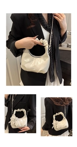 Detail der cremefarbenen Handtasche mit Falten Griff und Perlen Bogen Anhänger