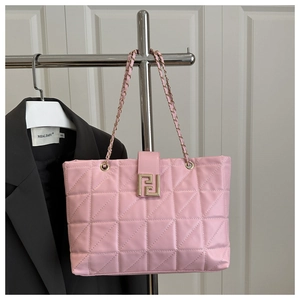 Detailed view of pink quilted tote bag with gold chain strap and geometric metal buckle