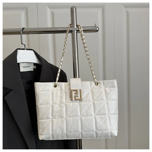 Detail of white leather tote with triangle quilting and gold chain strap on blazer