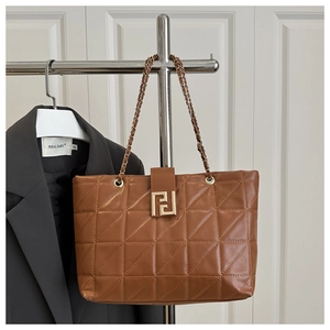 Detail of brown quilted faux leather tote bag with gold chain strap and geometric buckle
