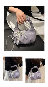 Detail einer lavendelfarbenen Plissee-Handtasche mit Spitzenschleife und Perlenanhänger