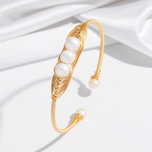 Bracelet jonc ouvert doré avec fil enroulé et cinq perles naturelles sur de la soie