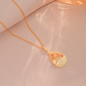 Collier doré élégant avec pendentif goutte ajouré, perles et pierres rouges