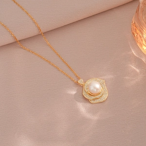 Elegant gold rose pendant necklace with diamonds and a large freshwater pearl