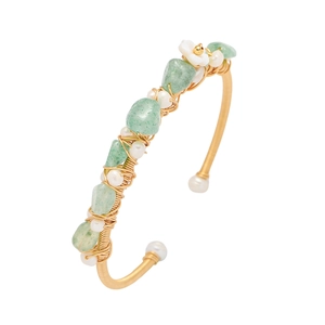 Macro detail of gold wire-wrapped bracelet with natural green jade and white pearls