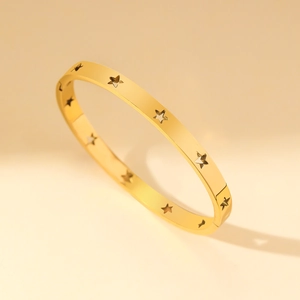Minimalist gold stainless steel bangle featuring hollow star patterns and a secure clasp