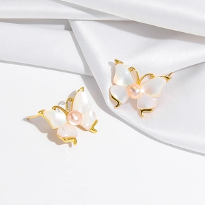 Elegant gold butterfly stud earrings with shell wings and pink freshwater pearl center