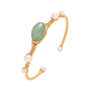 Detail of handmade gold wire-wrapped bangle with green gemstone and white pearls