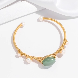 Detail of handmade gold wire-wrapped bangle with green aventurine and white pearls
