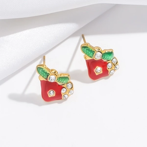 Close-up of red enamel apple earrings with green leaves and inlaid rhinestones