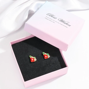 Detailed view of red apple earrings with sparkling rhinestones in a gradient gift box