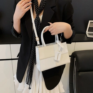 Chic cream and white color-block handbag with dual handles and adjustable shoulder strap