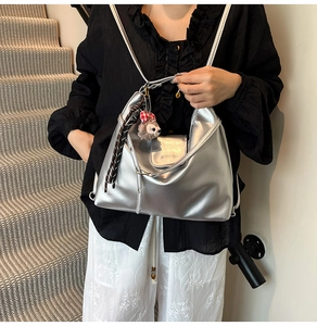 Detail of silver metallic hobo bag featuring fine pleated texture and chain strap