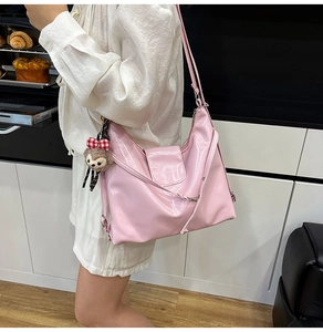 Pink patent leather tote bag detail with cute teddy bear charm and sleek shoulder strap