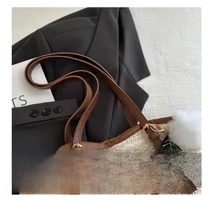 Détail d'un sac cabas en paille tissée avec anses en cuir et broderie de lettres