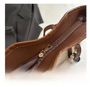 Détail de la fermeture éclair métallique sur sac tissé avec pendentif en perles