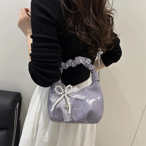 Purple patent leather pleated handbag with white lace bow and pearl heart charm