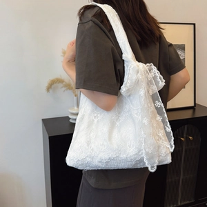 Elegant white lace tote bag with floral embroidery and large bow detail shown on shoulder
