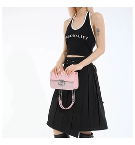 Detailed macro shot of a pink crossbody bag featuring a silver ring buckle and chain strap