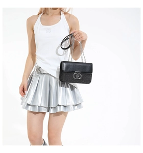 Close-up of metal CD lock and sequin texture on black chain shoulder bag
