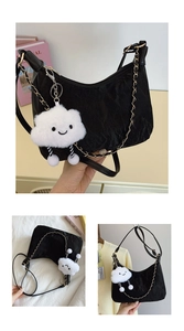 Close-up of black pleated half-moon tote bag with cute cloud charm and gold chain detail