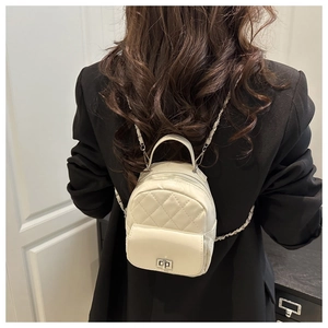 Detail eines gesteppten weißen Mini-Lederrucksacks mit Kette und Metall-Drehverschluss