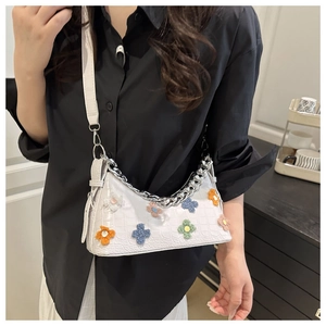 Detail of white crocodile pattern bag with colorful fuzzy 3D flowers and silver chain
