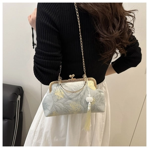 Detail of vintage floral crossbody bag with gold metal frame and delicate chain strap
