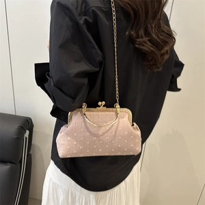 Sac à bandoulière rétro rose avec motif jacquard et chaîne dorée porté par mannequin