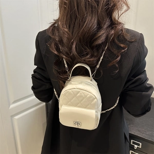 Weißer gesteppter Mini-Rucksack mit Kettenriemen auf einem schwarzen Blazer-Modell