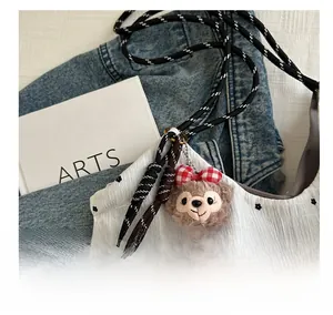 Detail of floral drawstring bag featuring plush bear charm and black-and-white rope handle