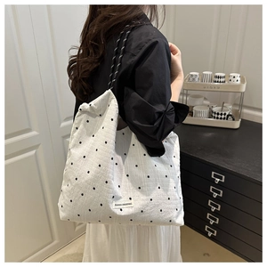 Close-up of white waffle fabric tote bag with star patterns and rope handles