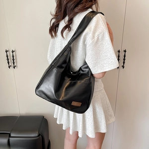 Retro black PU leather tote bag with large capacity for women shown in a shoulder carry pose